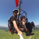 Параплан в тандеме с ребенком, пилотом и пассажиром летит над полями в Санкт-Петербурге