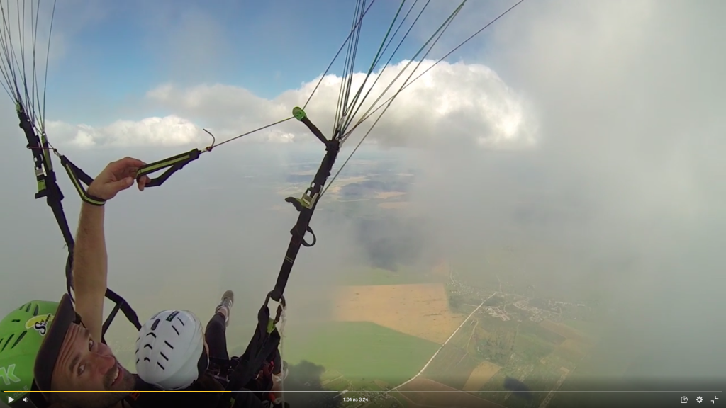 Парапланерист летает среди облаков над Санкт-Петербургом