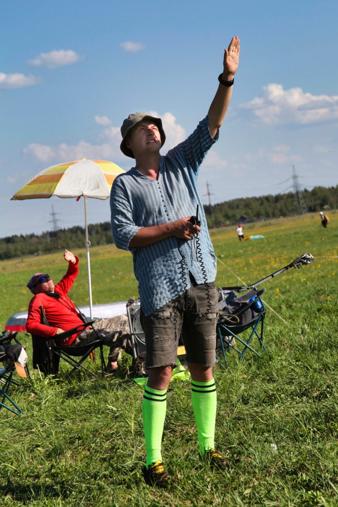 Пилот инструктор и основатель школы Скайстрим закрывает лицо от солнца