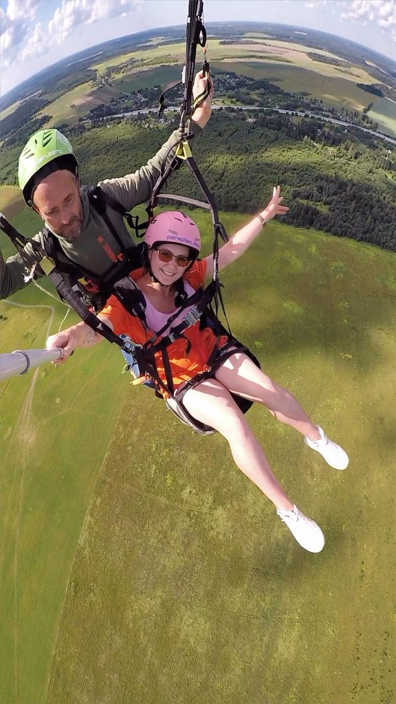 Инструктор и пассажир в тандеме на параплане парят в воздухе.